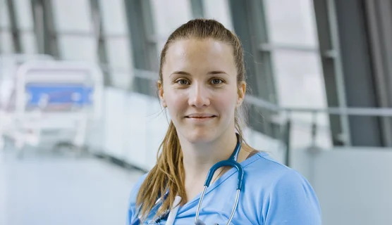 Ung gravid læge på arbejde i hospitalsmiljø.