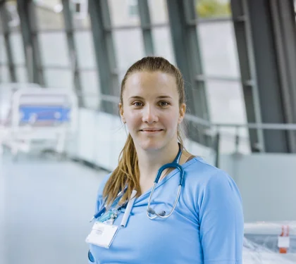 Ung gravid læge på arbejde i hospitalsmiljø.