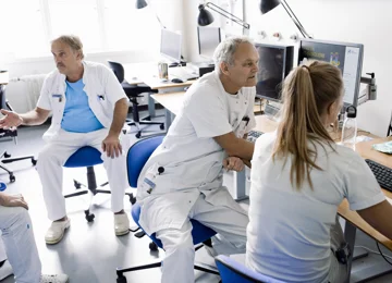Læger som taler og arbejder sammen på et fælles kontor på et hospital.