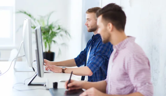 To mænd arbejder ved en computer