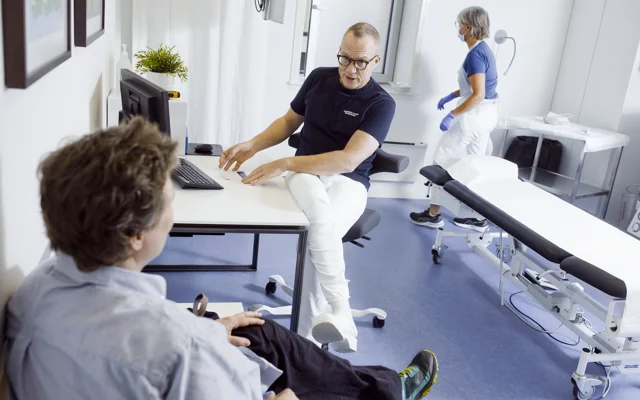 Patient og læge taler i et klinikværelse