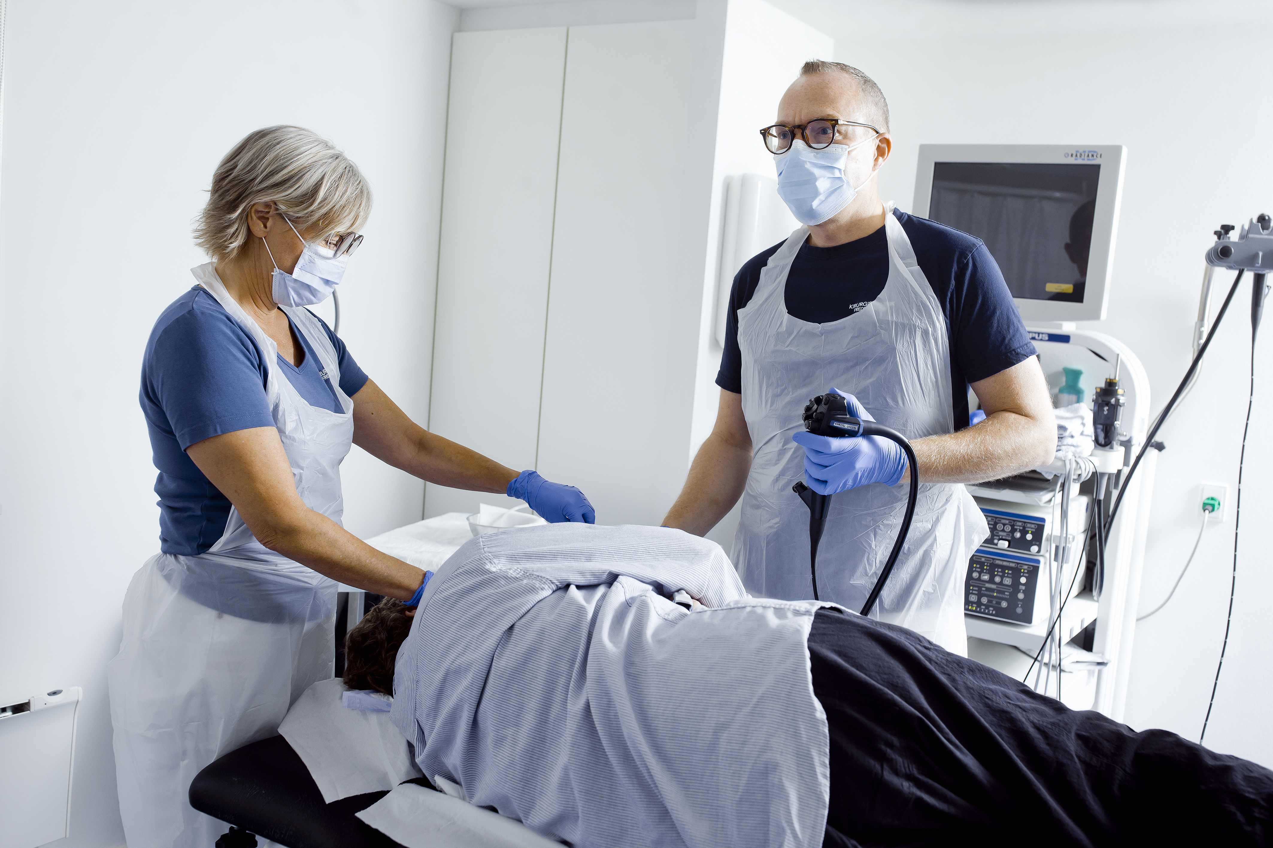 En læge og en sygeplejerske undersøger en patient