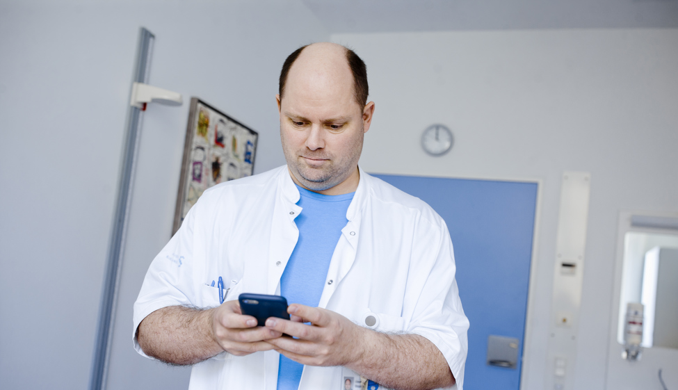 Læger ser på sin smartphone.