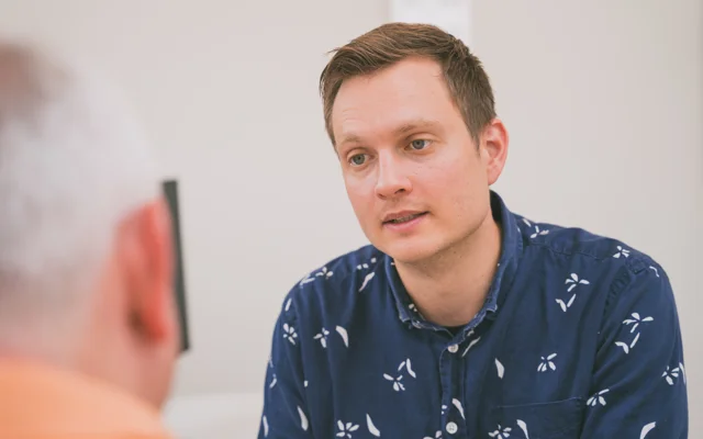 Ung læge taler med patient i klinik