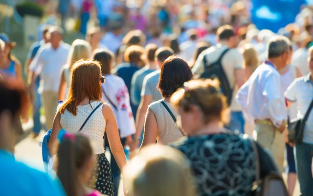 Mennesker ses med ryggen til gående på gaden sommer